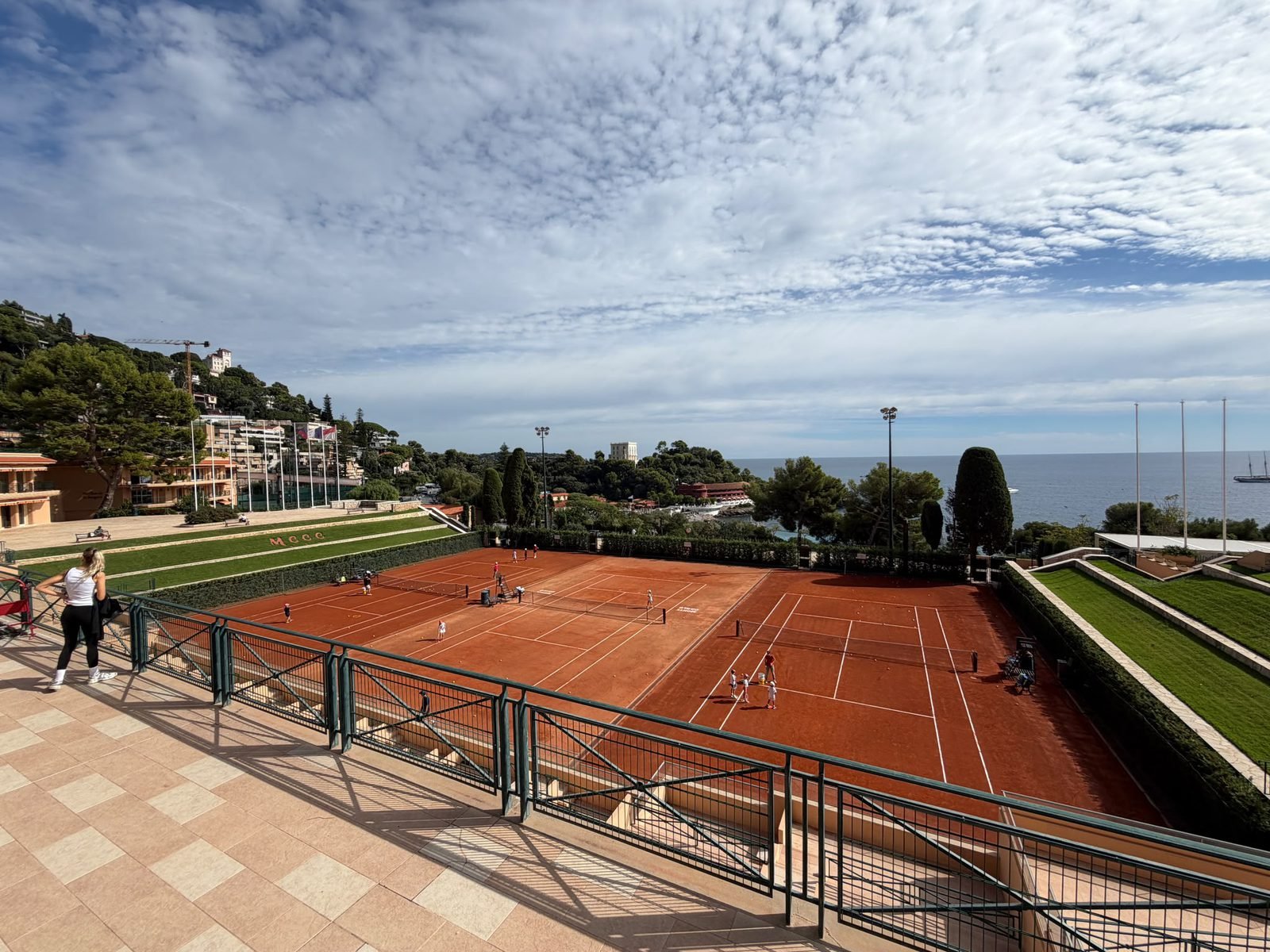 Clay tennis courts at the Monte-Carlo Country Club with the Mediterranean behind them